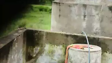 Indian village girl bathing near water tank outdoor